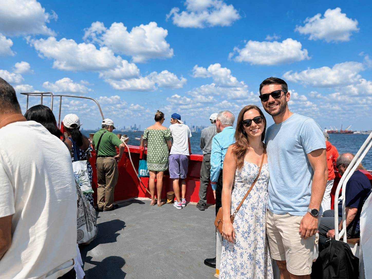 A couple poses on the bow of the boat during their Brooklyn Skyline Cruise.