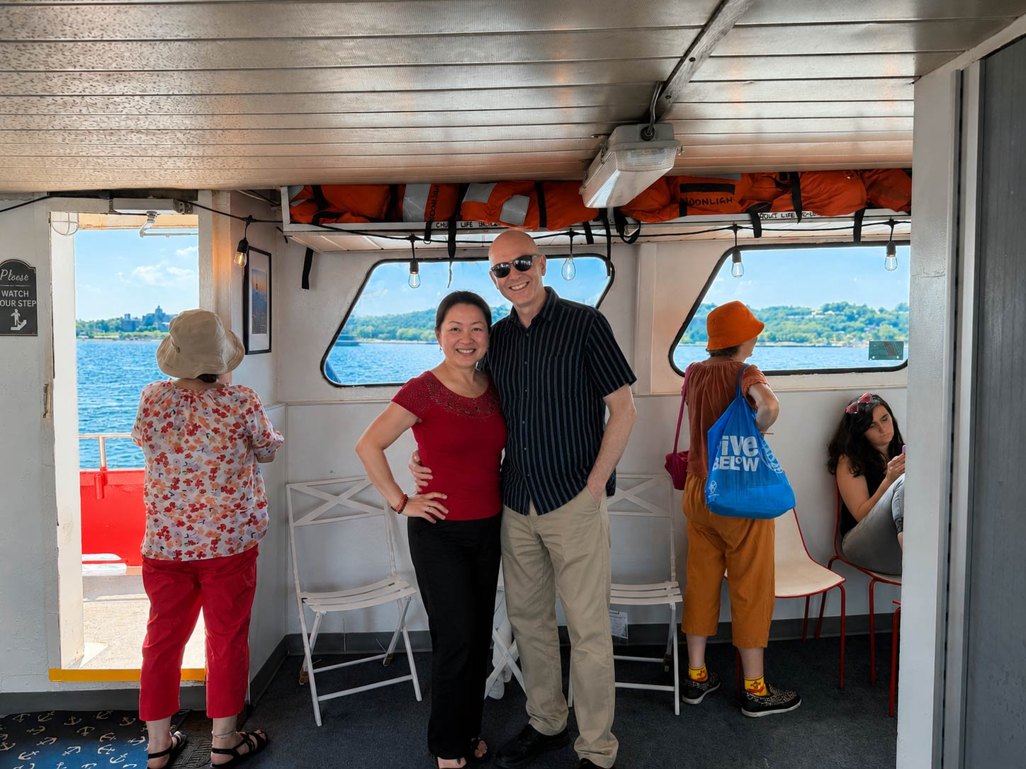 A couple poses inside the boat away from the sun.